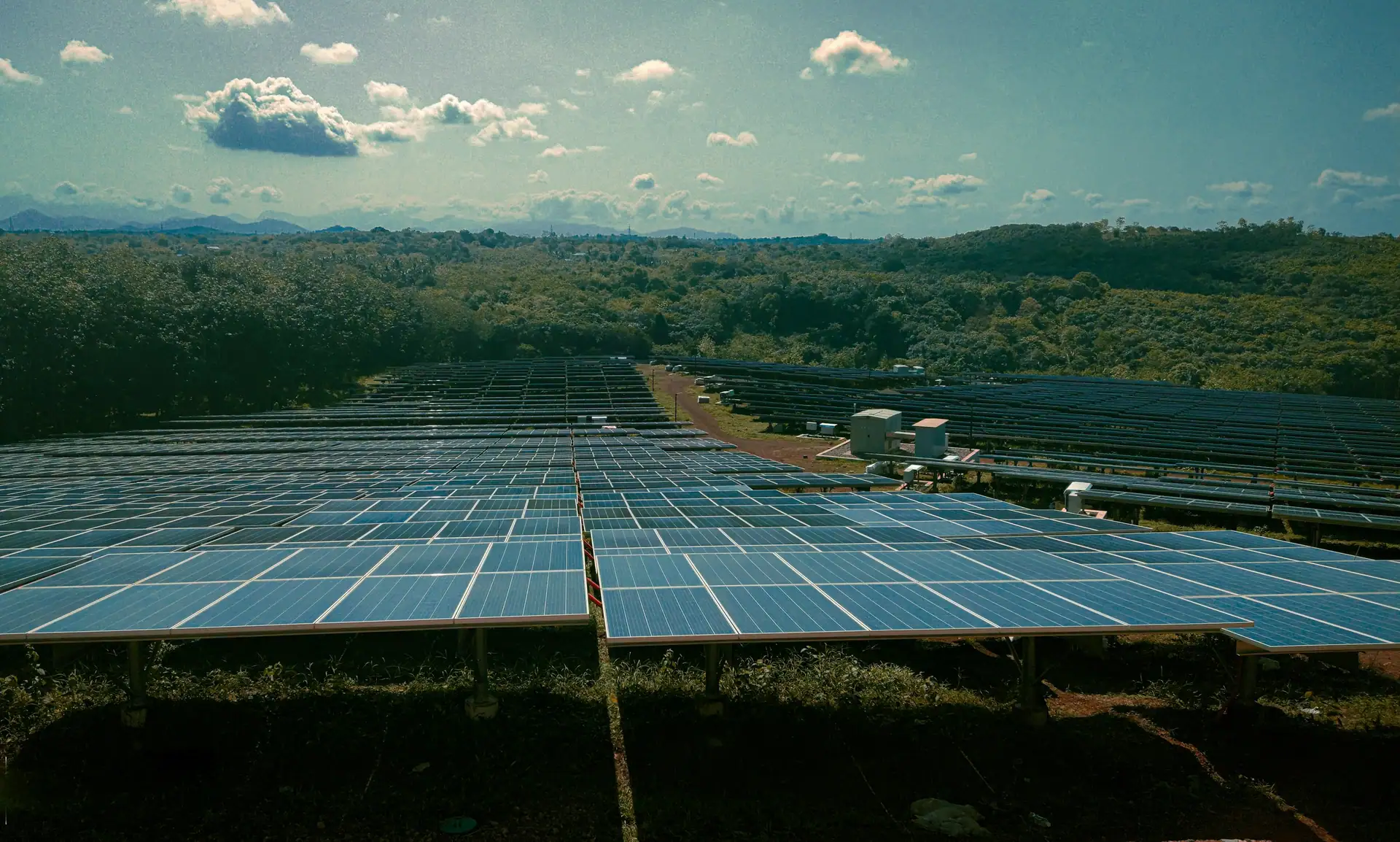 Rows of solar panels in green, hilly country